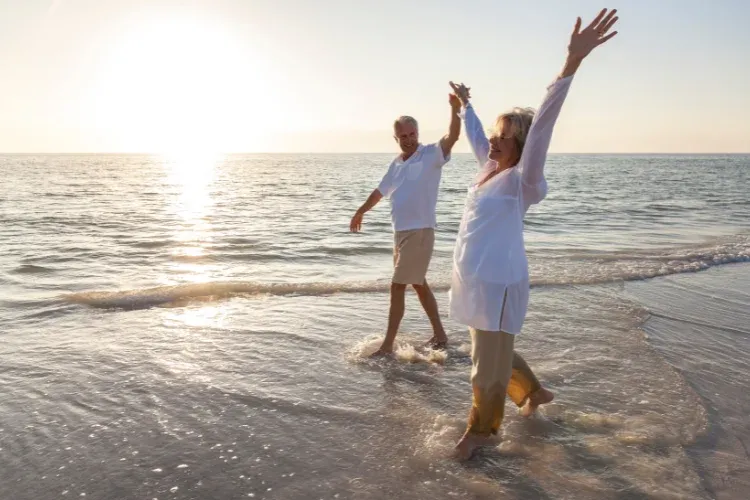 People walking along a Costa del Sol beach in winter sunshine – cost of living Costa del Sol vs London New York Toronto